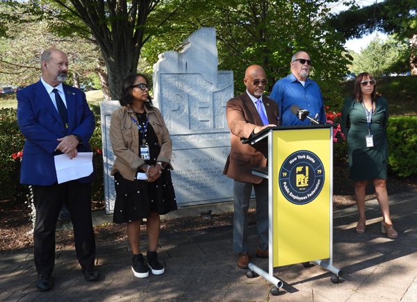 PEF President Wayne Spence at the podium, surrounded by his leadership team.